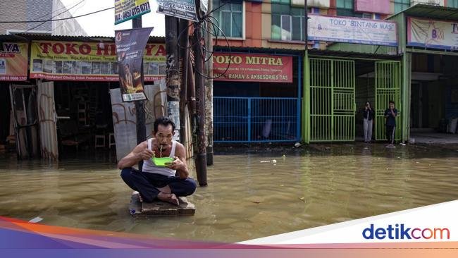 Aksi Santuy Bapak-bapak Makan Mie Instan di Tengah Banjir